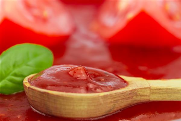 سس گوجه فرنگی در یک قاشق چوبی غذای گیاهی خانگی و سالم
