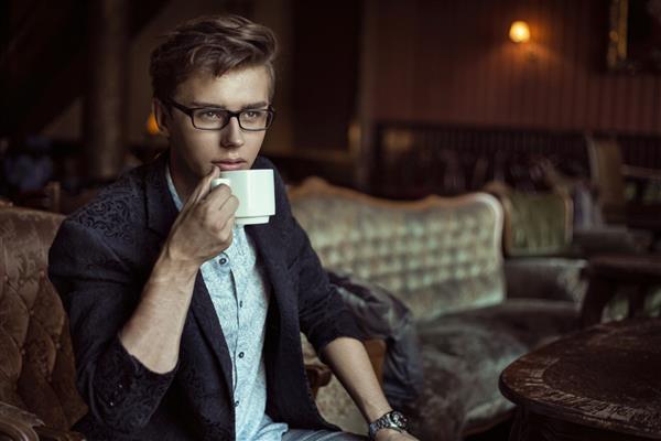 مرد جوانی که قهوه می نوشد