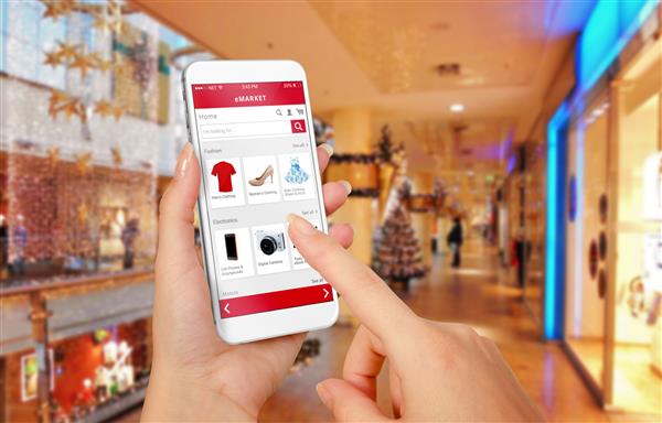 تلفن های هوشمند خرید آنلاین در دست زن در طول کریسمس مرکز خرید در پس زمینه