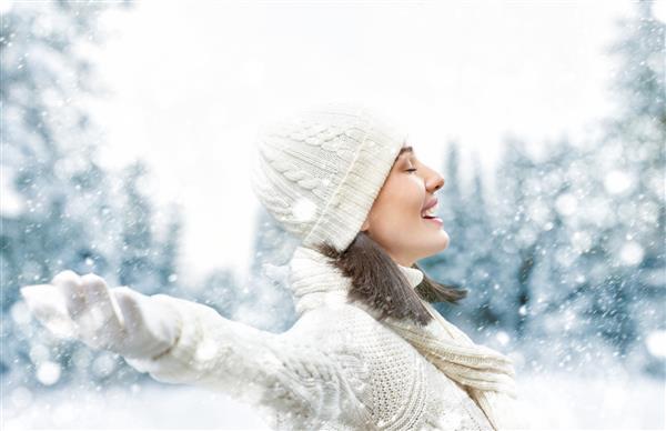 زن جوان شاد در پیاده روی زمستانی در طبیعت