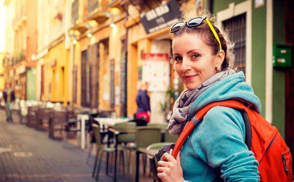 یک دختر مسافر زیبا در خیابانی در شهر اروپا