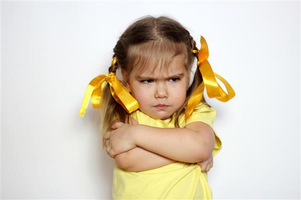 دختر کوچک عصبانی با تی شرت زرد روی زمینه سفید