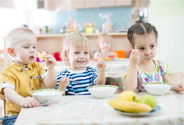 بچه های بامزه در مهد کودک غذا می خورند
