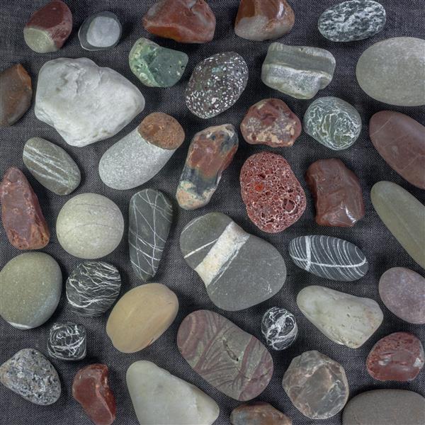 سنگ های دریا در پس زمینه بوم خاکستری زمینه مناسب برای ایده یا پروژه شما