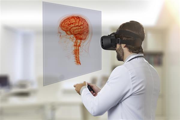 پزشک مردی در مطب خود با استفاده از عینک واقعیت مجازی به مغز مجازی نگاه می کند