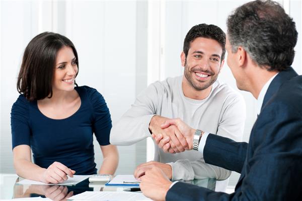 زن و شوهر خوشبخت با مشاور مالی شخصی خود در خانه معامله می کنند