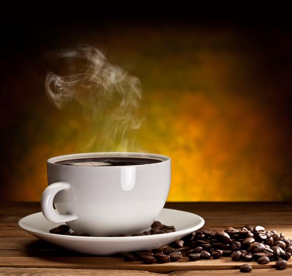 فنجان قهوه با دانه های قهوه در زمینه قهوه ای زیبا
