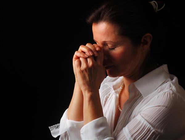 زنی زیبا با چشمانی بسته در دعای پرشور