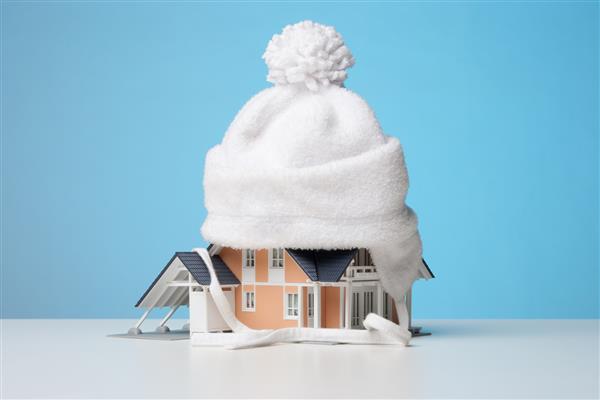 کلاهک کودک مدل خانه در برابر نشت گرما - مفهوم عایق بندی خانه زمینه آبی