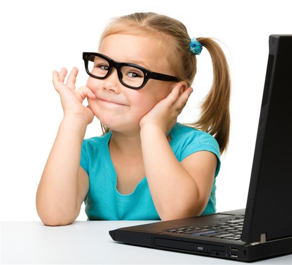 دختر کوچک ناز با لپ تاپ مشکی خود پشت میز نشسته و عینکی را بر تن دارد که روی آن سفید شده است