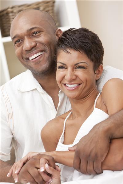 زن و مرد خوشبخت در خانه نشسته و با هم لبخند می زنند