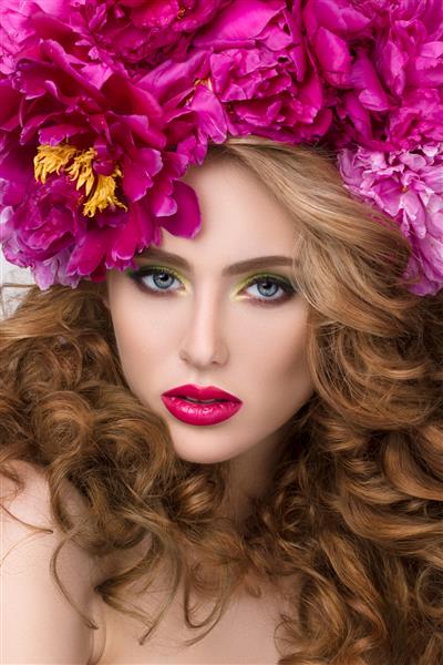 پرتره زیبایی از یک دختر زیبا جوان با تاج گل در موهایش که رژ لب صورتی روشن بر تن دارد آرایش روشن تابستانی مدرن