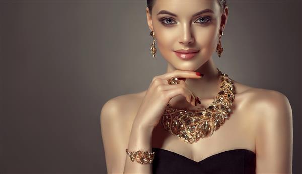 پرتره زن جوان زرق و برق دار که در مجموعه جواهرات از گردنبند انگشتر دستبند و گوشواره پوشیده شده است مدل چشم آبی بسیار آرایش و مانیکور جذابی را نشان می دهد