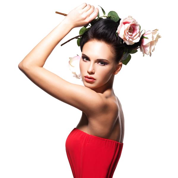 پرتره زن جوان زیبا با لباس قرمز با گل در مو - جدا شده روی سفید