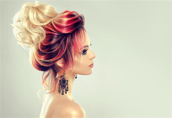 نقاشی مو زن جذاب جوان با موهای چند رنگ در مدل موهای ظریف شب با نان بلوند بزرگ جمع شده است آرایش مو و رنگ مو