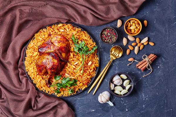 کبسای مرغ - برنج عربی خانگی با مرغ بو داده یک چهارم بادام کشمش و سیر در یک بشقاب سیاه روی زمینه بتنی تیره
