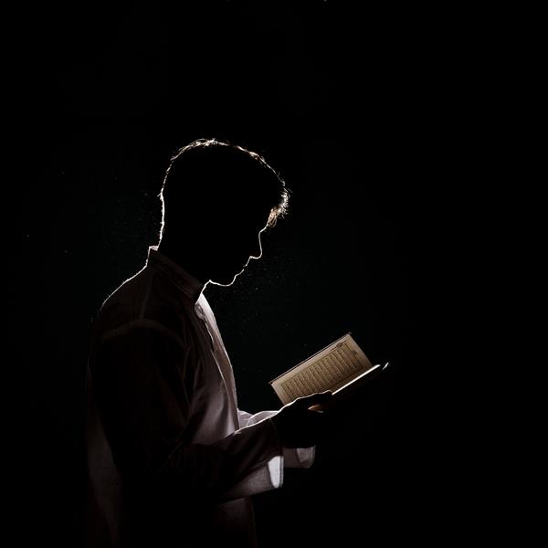 تصویر مردی که در قرآن می خواند