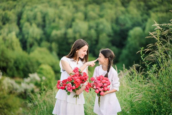 دو خواهر که لباس سفید پوشیده اند تابستان را با هم خوش می گذرانند