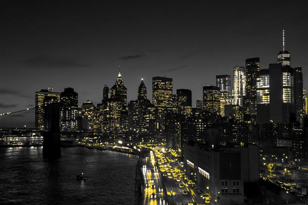 افق شب سیاه و سفید شهر نیویورک با نورهای زرد طلایی درخشان در مرکز شهر منهتن نیویورک