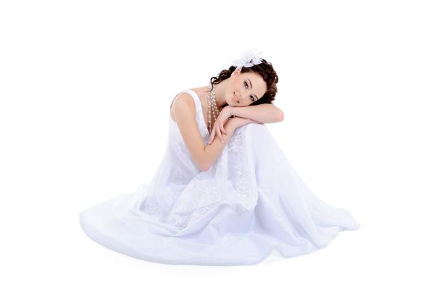 زن جوان زیبا با لباس عروس سفید