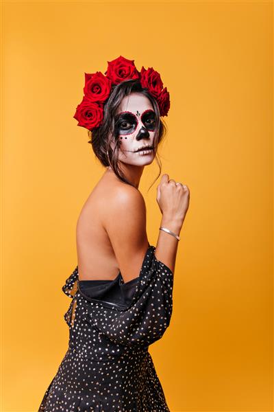 دختر لاغر با موهای تیره با حالتی زیبا که در لباس ژست گرفته شانه های برهنه پرتره بانوی مرموز مکزیکی با ماسک بالماسکه زامبی