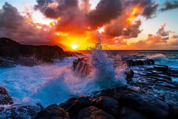 مناظر زیبا از صخره ها در کنار دریا در حمام ملکه ها کائوآی هاوایی در غروب آفتاب