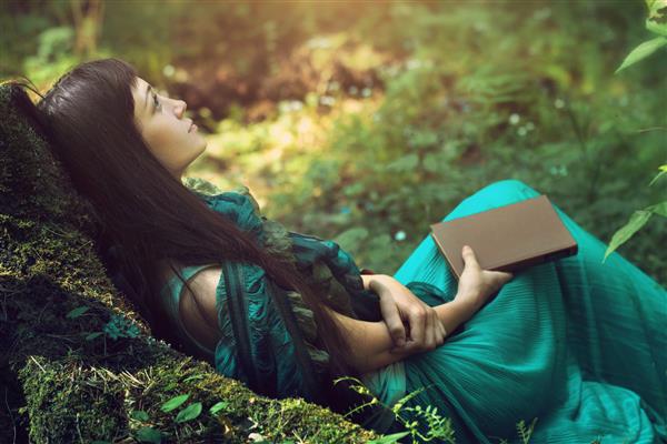 تصویر مرموز از یک زن زیبا در جنگل دختر مرموز تنها در پس زمینه طبیعت وحشی زن در جستجوی خود