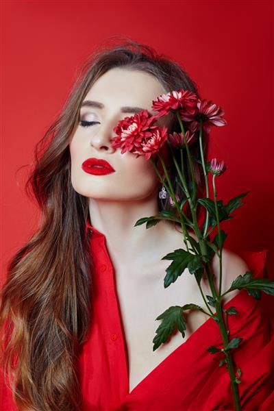 زنی با موهای مجعد در لباس قرمز و دست گل