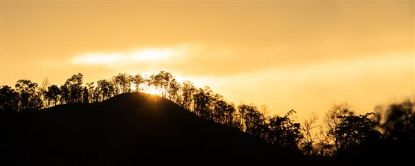غروب زیبای پشت صفحه کوهستان از نزدیک غروب آرام خورشید یا طلوع خورشید بر فراز کوه و جنگل زیبا - قله با فضای کپی
