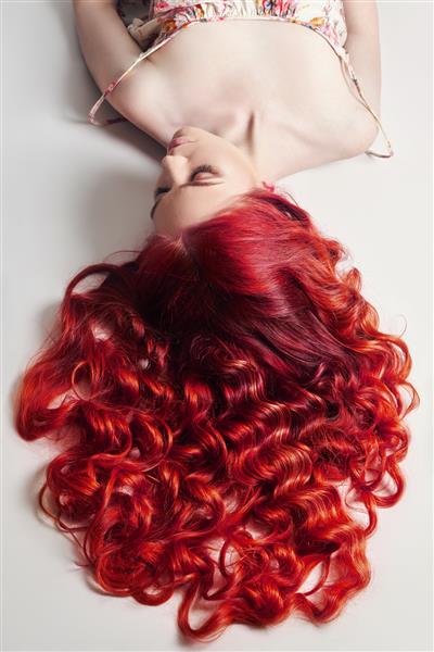 رنگ آمیزی روشن خلاقانه موهای یک زن مراقبت دقیق از ریشه مو رنگ روشن برای رنگ کردن موهای بلند قوی لوازم آرایشی طبیعی زیبایی طبیعی زنی با موهای قرمز مو قرمز بنفش