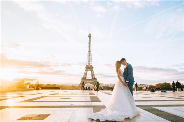 زوج متاهل عاشقانه خوشبختی که در نزدیکی برج ایفل در پاریس در آغوش گرفته اند