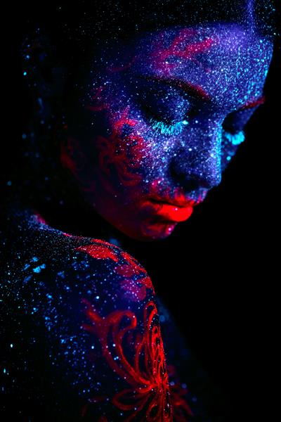 پرتره نمایه یک دختر بیگانه زیبا هنر بدن ماوراء بنفش آسمان شب آبی با ستاره ها و چتر دریایی صورتی