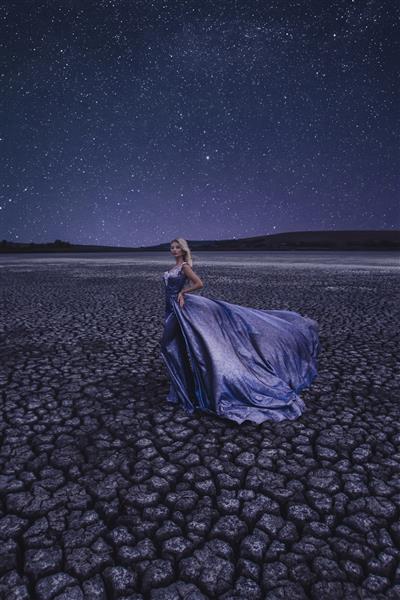 زن زیبا در دریاچه خشک در شب