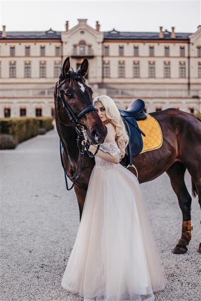 زن زیبا با اسب در نزدیکی قلعه