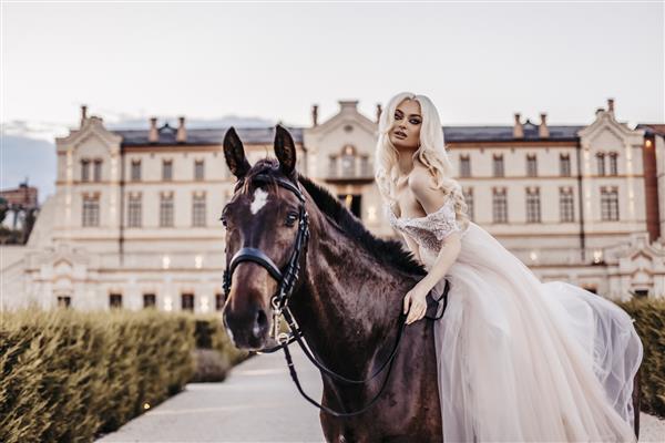 زن زیبا با اسب در نزدیکی قلعه