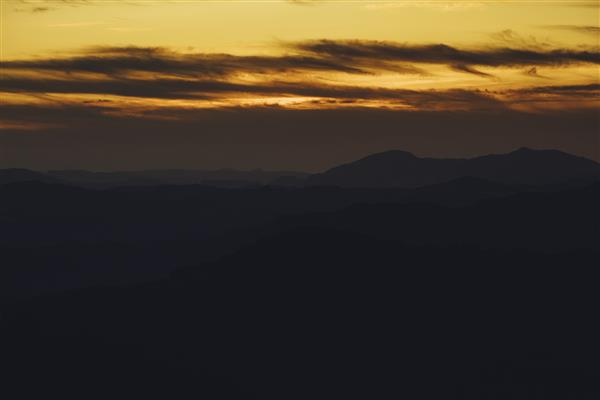 کوه پانوراما و پس‌زمینه غروب خورشید دراماتیک آسمان به رنگ طلایی