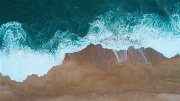 عکس هوایی از برخورد امواج دریا به ساحل شنی