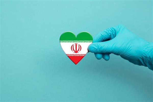 دست کارکنان پزشکی با دستکش جراحی و قلب پرچم ایران