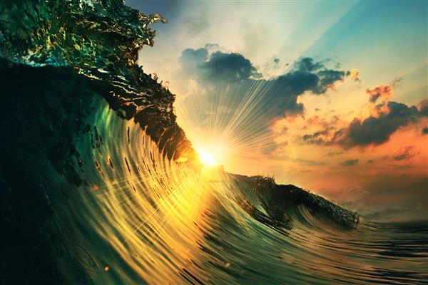 موج رنگارنگ اقیانوسی که در زمان غروب آفتاب فرو می‌ریزد