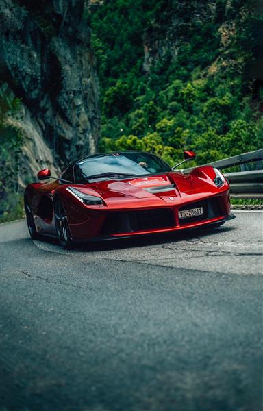 ماشین قرمز اسپرت در جاده کوهستانی
