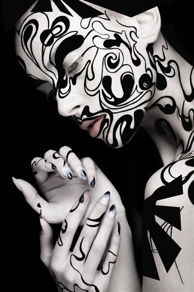 دختر زیبا با آرایش و ناخن های سیاه و سفید هنری چهره زیبایی خلاق عکس گرفته شده در استودیو