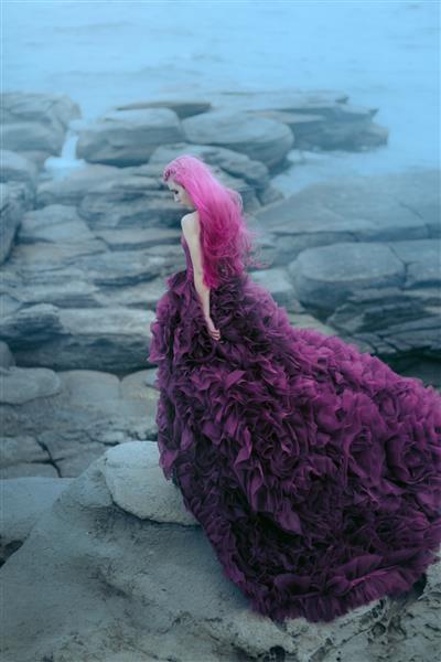 زنی با لباس بنفش که به دریای کوه نگاه می کند