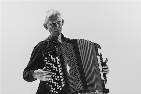 پرتره مرد ارشد در حال نواختن آکاردئون در حال اجرای موسیقی در حال اجرای تصویر سیاه و سفید پس زمینه سفید