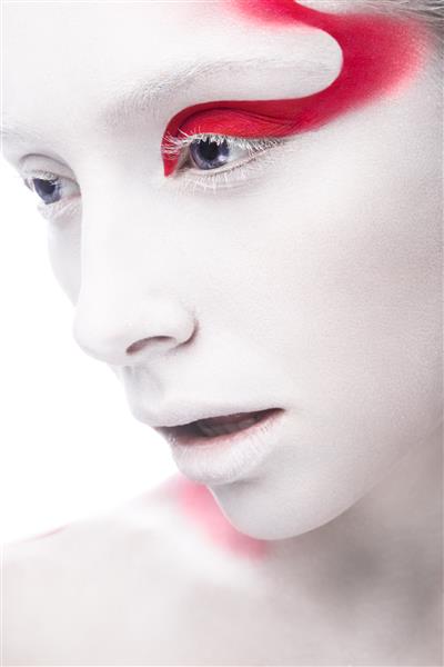 دختر مد هنری با پوست سفید و رنگ قرمز روی صورت تصویر زیبایی هنری خلاقانه که در استودیو روی پس‌زمینه سفید گرفته شده است