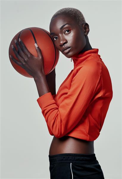فقط سعی کنید عکس استودیویی یک زن جوان جذاب در حال بازی بسکتبال در پس زمینه خاکستری را از من بگیرید