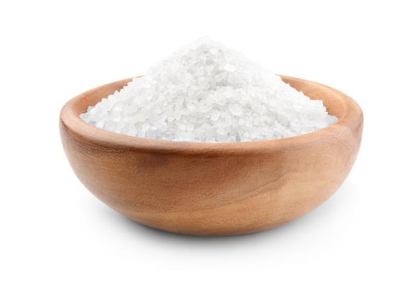 نمک در یک کاسه چوبی جدا شده در زمینه سفید