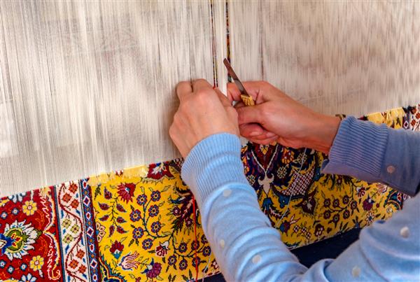 استانبول ترکیه - 9 آوریل 2019 زنی که فرش سنتی استانبولی با پشم رنگارنگ می‌بافد istanbul ترکیه