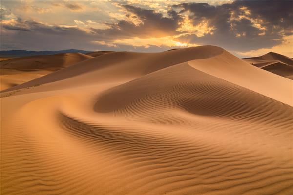 غروب خورشید بر فراز تپه های شنی در بیابان منظره خشک صحرای صحرا