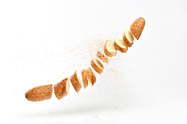 باگت با دانه کنجد که در هوا پرواز می کند نان تازه پخته شده برش داده شده باگت فرانسوی محصول نانوایی سنتی نان گندم ترد خوشمزه شناور مفهوم غذای مگس