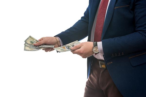 تاجر موفقی که پول نقد دلار آمریکا جدا شده در پس زمینه سفید را در دست دارد